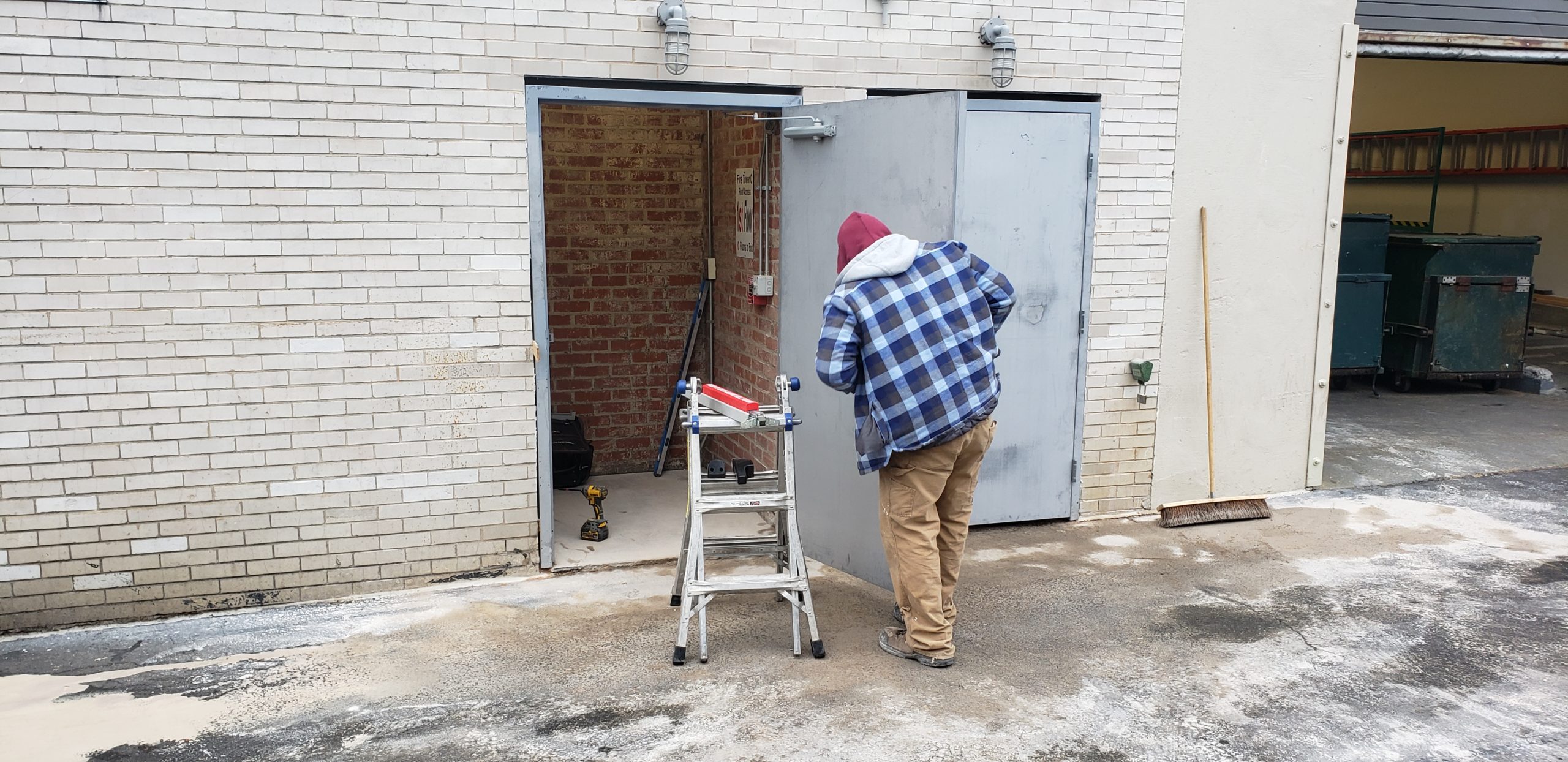 a 24 Hour Door technician working on commercial steel door