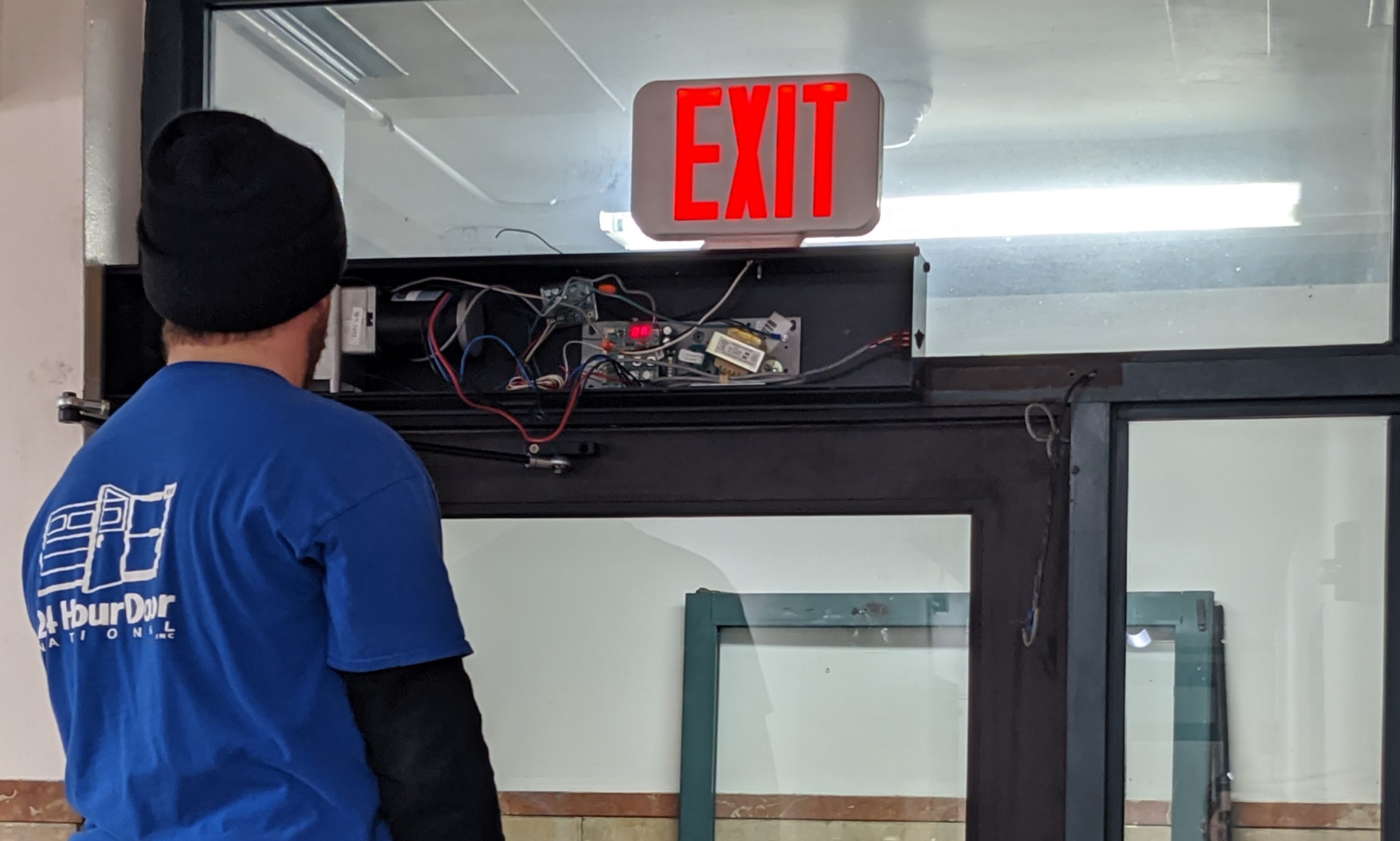 A 24 Hour Door Technician Repairing the electronics on an automatic door