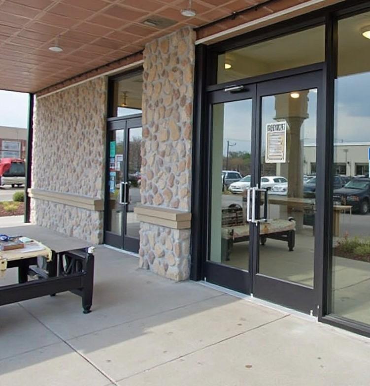 Technician installing a commercial storefront door at a retail building in Cincinnati, OH