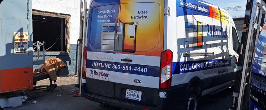 A 24 Hour Door service van in Buffalo, NY with a technician performing commercial door repairs at a local facility