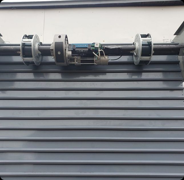 Rolling commercial door operator system serviced in Cincinnati, OH by A 24 Hour Door, showing springs and motor mechanism.