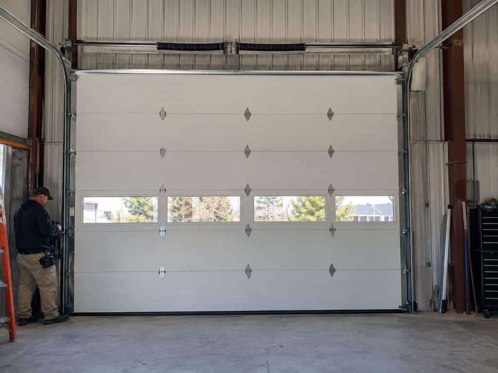Technician inspecting a sectional overhead door for Commercial Garage Door Installation and Replacement Atlanta, GA.