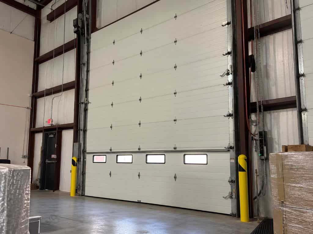 Large sectional warehouse door for Commercial Garage Door Repair Atlanta, GA at an industrial facility.