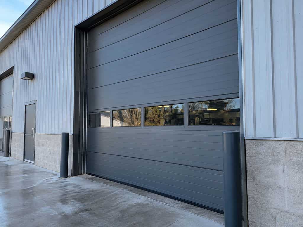 Large gray sectional overhead door representing Industrial Door Services Atlanta, GA at a commercial warehouse.